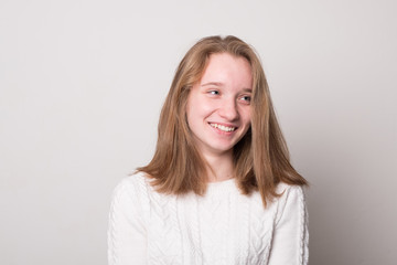 Wall Mural - Cheerful teen girl. Studio image of a cute smiling young girl on a gray background.