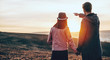 © Strelciuc - Caucasian man walking hand in hand in a field with his woman is pointing to the landscape