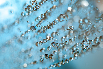 Wall Mural - Falling water drops on blue background macro wet rain