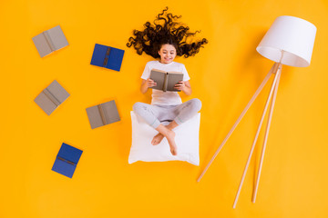 Sticker - Full size high angle above flat lay view photo of little pupil lady lying floor morning reading sit on white pillow comfy wear pajama pants t-shirt isolated yellow color background