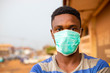young handsome man african wore face mask preventing, prevent, prevented himself from the outbreak in his society.