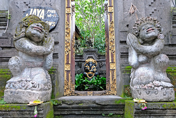 A stone entrance door decorated with stone statues of Balinese gods and demons