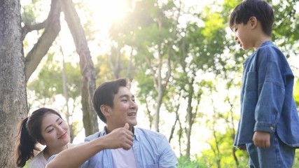 Wall Mural - young asian mother father and son relaxing having fun outdoors in woods