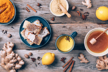 Poster - Yellow turmeric latte drink. Golden milk with cinnamon, turmeric, ginger over grey background. Top view. Antiviral beverage. Healthy ayurvedic drink.