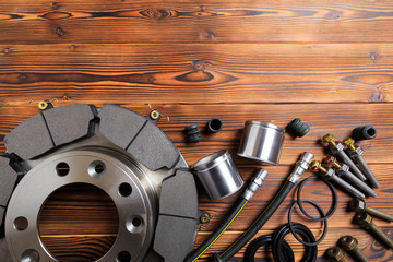 Wall Mural - brake parts on wooden background  brake pads, disc, brake hose, guides, cylinders- Image