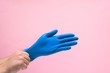 © Taranova_ksenya - medical blue glove on the man's hand from the coronavirus on a pink background. space for text. protecting the body from viruses and bacteria