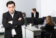 © JackF - Young businessman standing in office on backround with colleagues