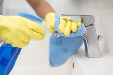 Close Up Hand Woman Wear Yellow Gloves And Fabric Doing Chores In Bathroom, Cleaning Bathroom Sink With Spray Of Water Tap Cleaner Disease Eliminate Bacteria. Housekeeping.