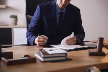 Wall Mural - Male lawyer working at table in office, closeup