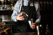 © fesenko - bartender preparing glass and shaker to make cocktail.