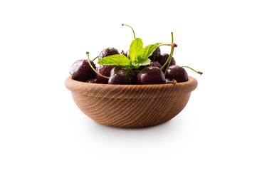 Wall Mural - Red cherries in bowl isolated on white background. Ripe cherries and mint leaves close-up. Sweet and juicy berry with copy space for text. Various fresh summer fruits isolated on white.