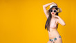 © anon - Beautiful,Sexy asian girl standing on yellow background in a pink bikini and smiling.Summer vocation happy trip concept.