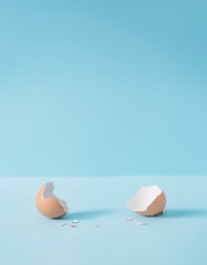 empty eggshell with creative copy space on pastel blue background. minimal easter holiday concept.