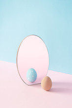 Creative Easter Concept With Egg And Mirror On Pastel Pink And Blue Background. Minimal Easter Holiday Idea.