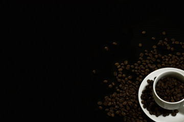 Coffee beans in a white coffee cup in a black background