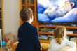 © Irina Schmidt - Cute little toddler girl and school kid boy watching animal movie or movie on tv. Happy healthy children, siblings during coronavirus quarantine staying at home. Brother and sister together. no face