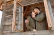 © wolfhound911 - couple in love looks out of the window, wooden house. The concept of buying new housing for young families.