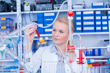 Sticker - Female laboratory assistant with chemical experiment in scientific laboratory. Female medical or scientific researcher using test tube on laboratory.