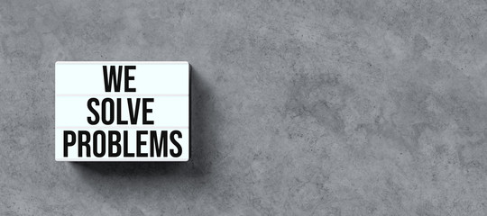 Wall Mural - lightbox with message WE SOLVE PROBLEMS on conrete background