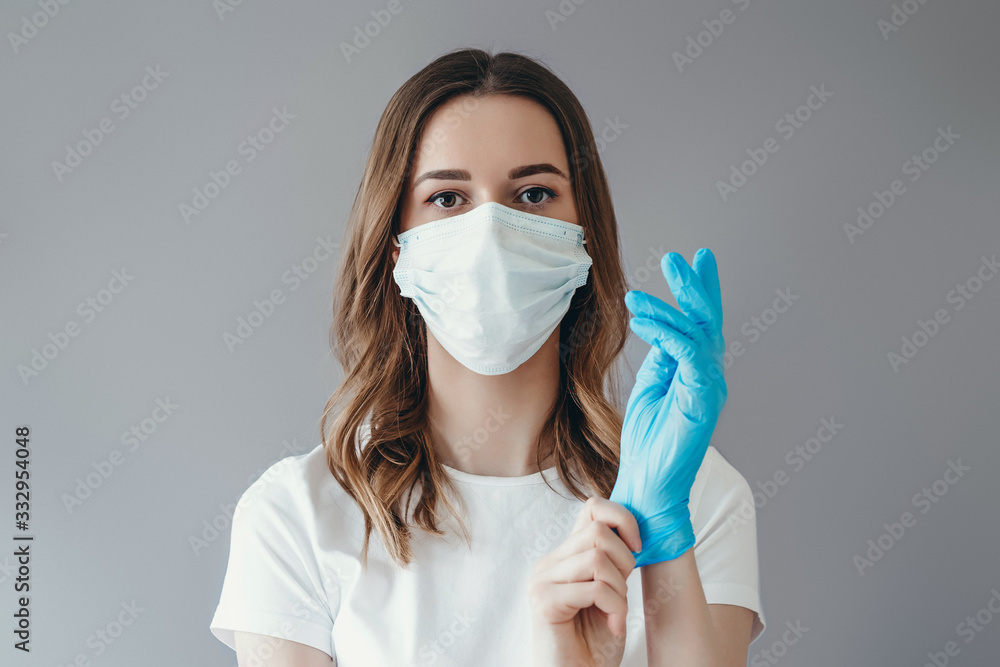 Young woman patient in a medical mask puts on protective surgical ...