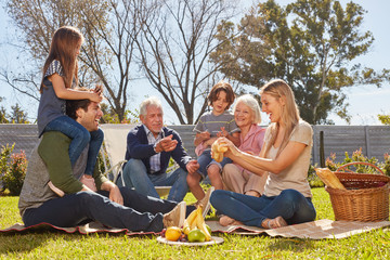 Wall Mural - Erweiterte Familie macht ein Picknick im Garten