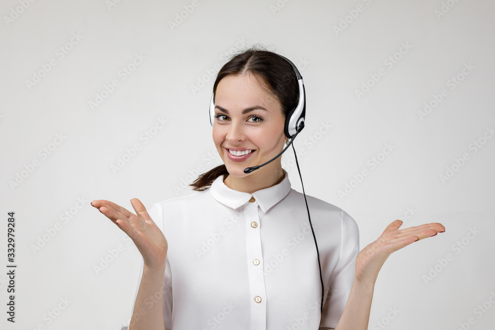 Beautiful smiling woman consultant of call center in headphones on gray background. female customer support operator with headset - obrazy, fototapety, plakaty 