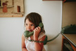 © Maria Manco/Stocksy - girl talks on old school phone