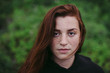 © Rob and Julia Campbell/Stocksy - Serious portrait of red haired teenage girl.
