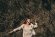© Sergey Filimonov/Stocksy - Smiling woman lying on grass