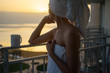 © Pietro Karras/Stocksy - Dreamy woman looking at sunset after bath