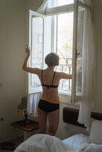 Female In Underwear Opening Window