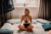Hippie Female Meditating On Bed