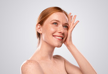 Charming Redhead Female With Naked Shoulders On Gray Background
