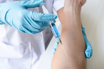 Doctor making injection vaccination patient to prevent pandemic of the disease, flu or influenza virus in clinic