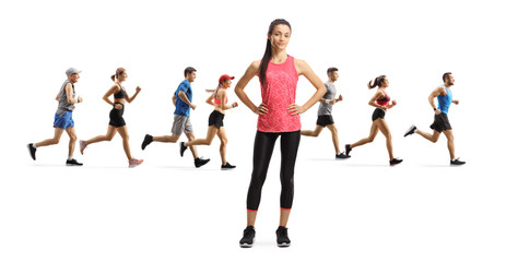 Wall Mural - Young slim female in sportswear standing and people running in the back