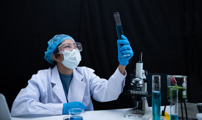 Wall Mural - Scientist woman research, Natural organic botany medical researcher holding test tube with blue fluorescent liquid.