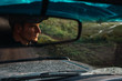 © Kike Arnaiz/Stocksy - Reflection of man in car rear view mirror