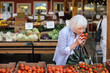 © Rob and Julia Campbell/Stocksy - Mature woman shopping at outdoor produce market.