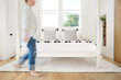 © Trinette Reed/Stocksy - Woman walking through modern design farmhouse bedroom