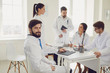 © Studio Romantic - Portrait of a practicing doctor on the background of collegues in the clinic office.