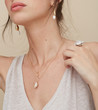 © leandro crespi/Stocksy - Detail woman wearing shell jewellery