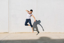 A Dancer Dancing In Front Of A Concrete Wall