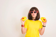 Teen Girl In Funny Glasses With Duck Face And Two Yellow Rubber Ducks Having Fun. Party Props, Photo Booth And People Concept.