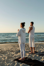 Barefoot Couple Meditating Near Sea