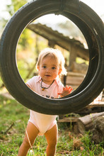 A Baby Girl Playing With Car Tire Swing
