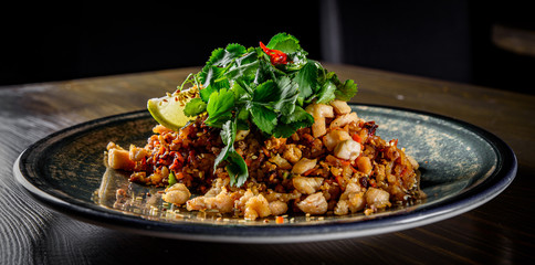 Wall Mural - Fried rice with chicken and vegetables in plate on wooden table background