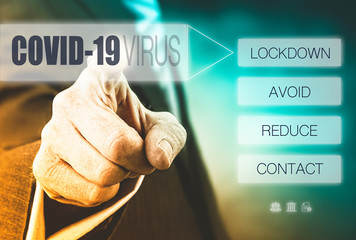 A mans hand pointing to a computerised display with a Covid-19 Virus message of Lockdown, avoid and reduce contact.