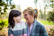 © Cavan Images - Grandma smiling at granddaughter in outdoor setting.