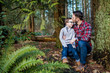 © Cavan Images - Father kissing young son on the forehead in forest.
