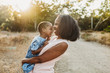 © Cavan Images - Close up of happy grandmother holding young granddaughter in sun